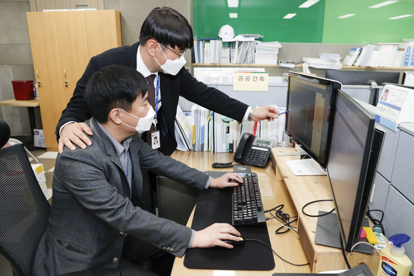 이문규 주무관과 윤여훈 주무관이 특허를 획득한 건축 인허가 관리시스템을 살펴 보고 있다.(자료제공=용인시)