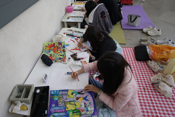 행사장에서 그림그리기를 하고 있는 학생들