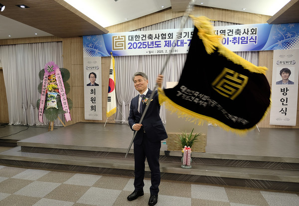 방인식취임회장이 건축사회기를 이양받아 흔들고 있다(사진:가평지역건축사회)